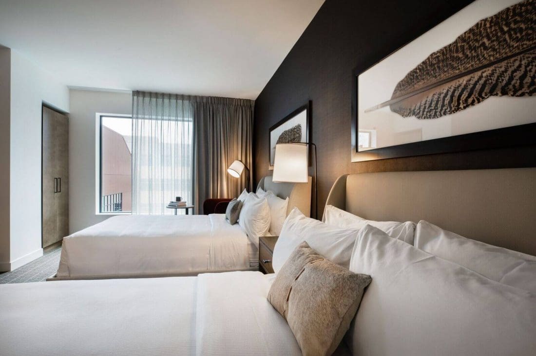 A deluxe QUEEN room featuring two beds and a window for a comfortable and relaxing stay.